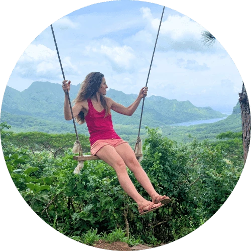 Emeline sur une balançoire, face à un paysage tropical